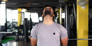 Man in gym doing a neck exercise 