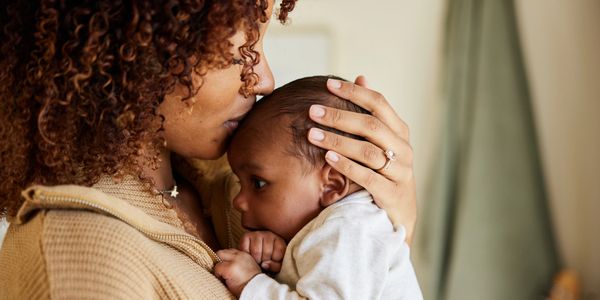 Mother and baby share a joyful, loving moment lying down.
