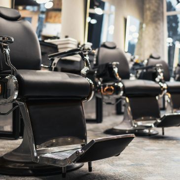 Row of black barber chairs in a barbershop.