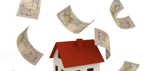 Model house surrounded by flying British ten-pound notes.