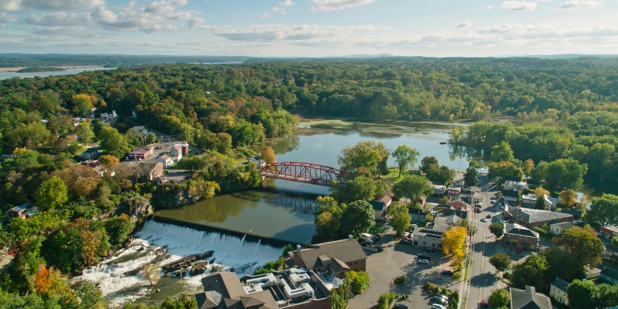 A riverside city with houses and bridges built over the flowing water.
