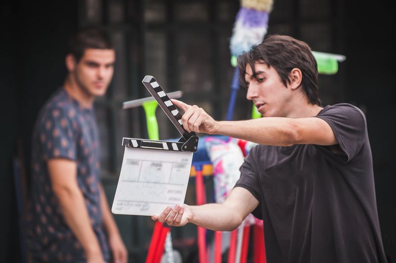 Filming on location. Man holding a clapper board in front of the camera, the filming process. Scene on location