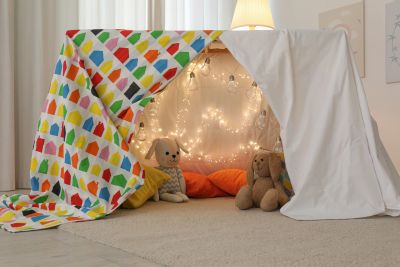 Pretend dragon cave tent made of sheets draped over a table. Pretend creative play. 