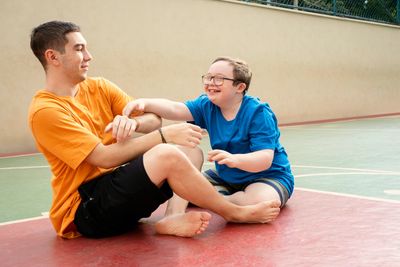 Two friends playing and smiling on a sports court.