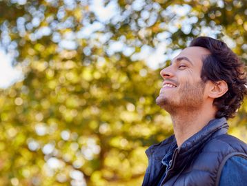 Man happily looking up outdoors.