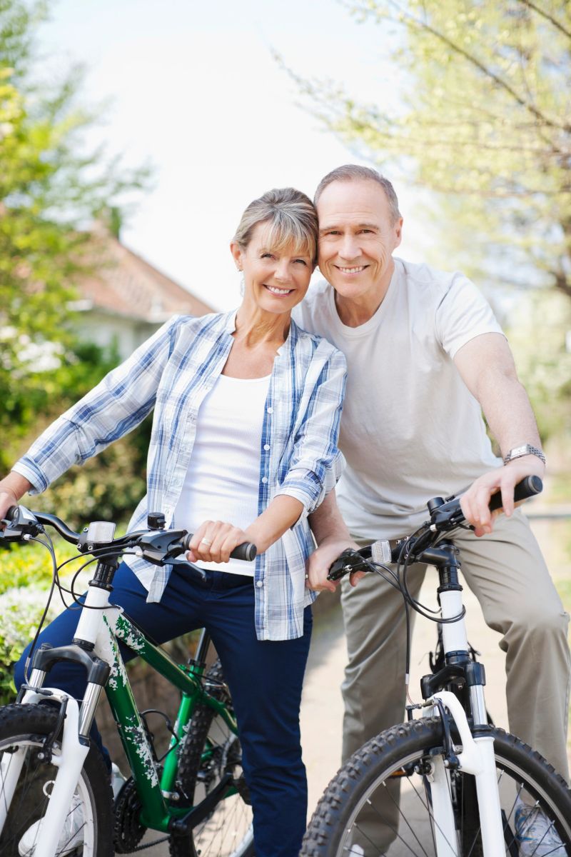 Portrait of smiling senior couple on bicycles