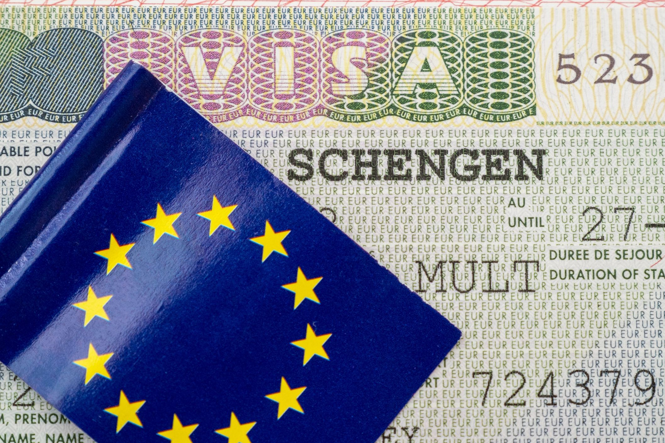 European Union passport over a Schengen visa document.
