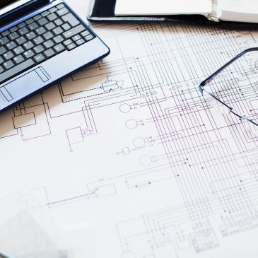 Laptop and glasses on an engineering schematic.