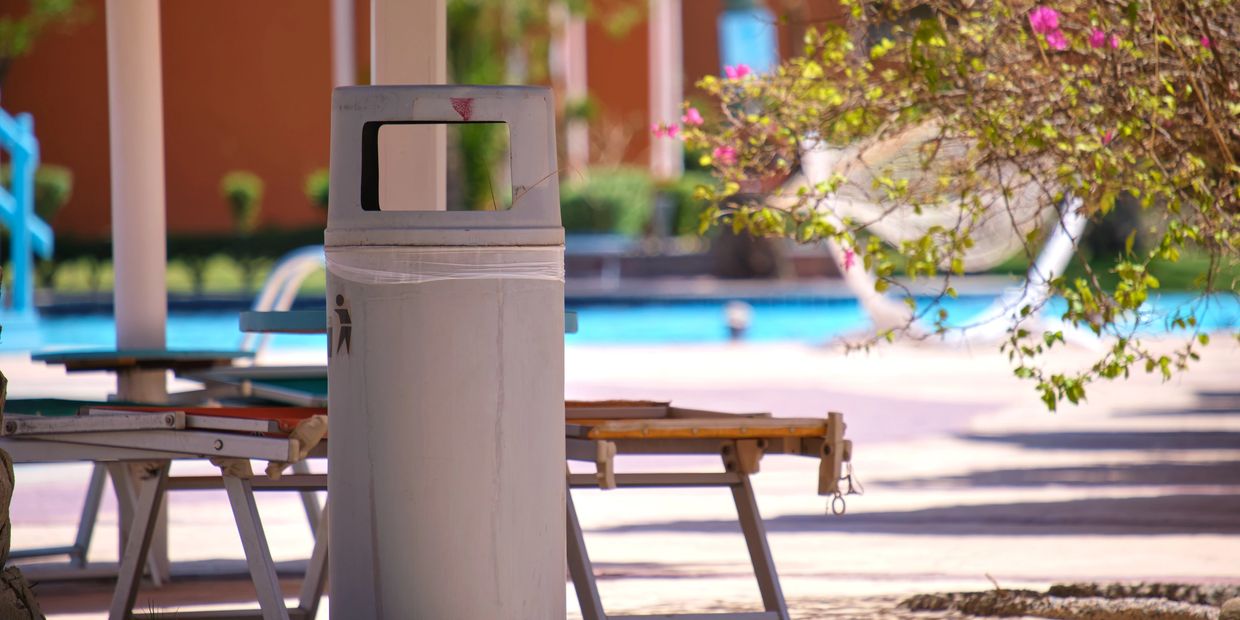 a community dumpster near a pool area 
