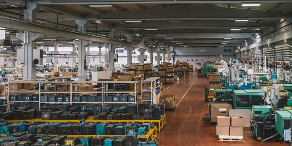 Spacious factory floor with organized machinery and boxed materials.