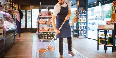 Man mopping the floor in a grocery store.