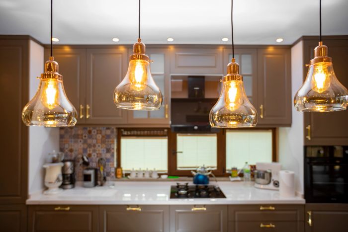 Modern kitchen with warm pendant lights and brown cabinetry.