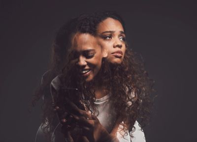 Double exposure of a woman with contrasting emotions.