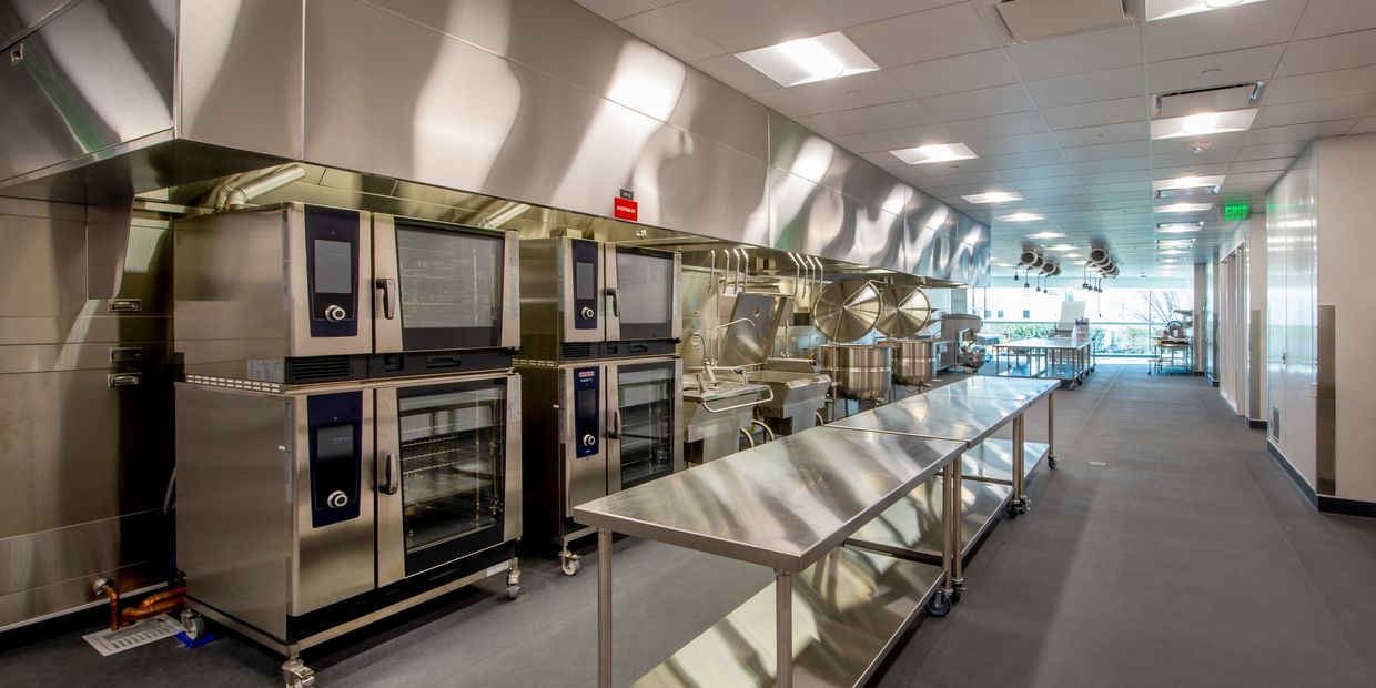 Modern commercial kitchen with stainless steel appliances.