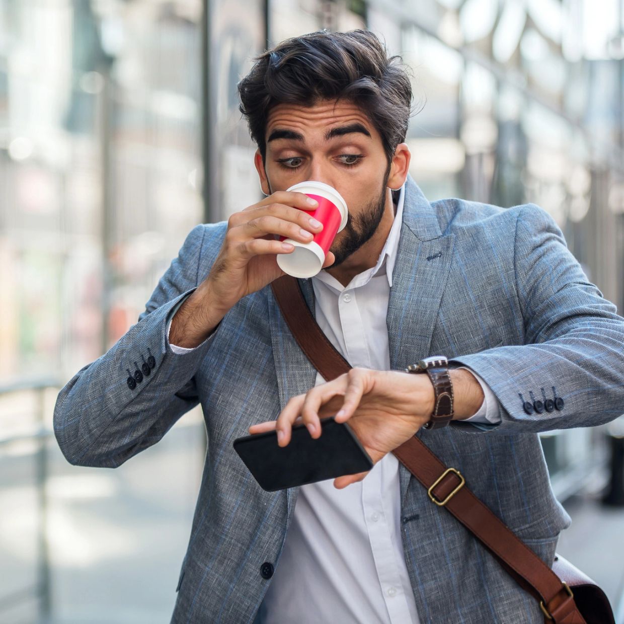 Man drinking coffee and checking watch.