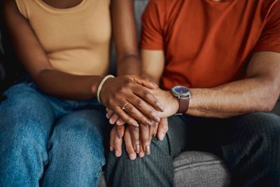 Hands of a couple holding each other kindly.