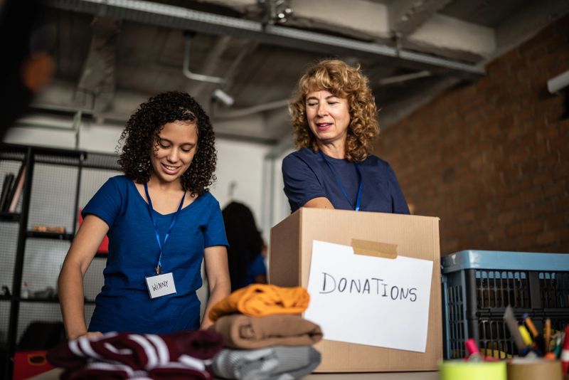 Volunteers arranging clothes donations in a community charity donation center
