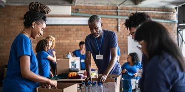 Volunteers packing boxes in a warehouse.