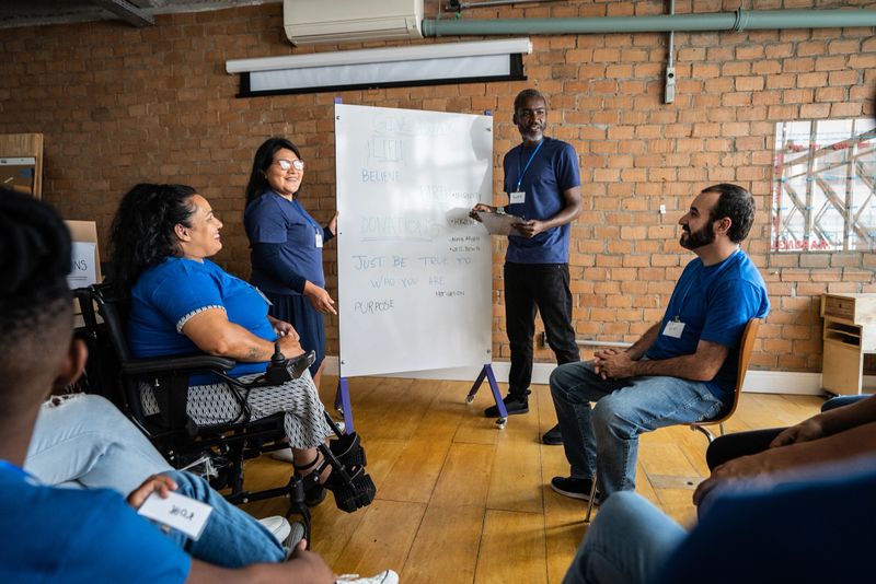 Mature man talking in a meeting at a community center - including a disabled person