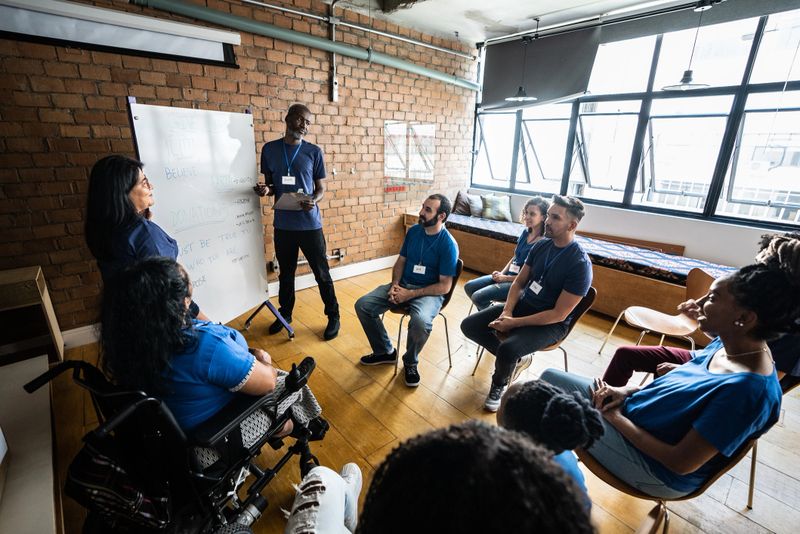 Mature man talking in a meeting at a community center - including a disabled person