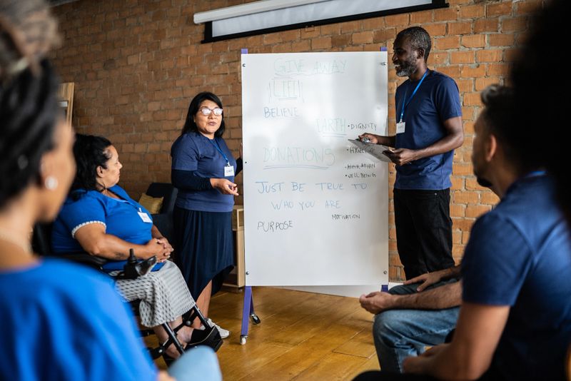 Mature man talking in a meeting at a community center - including a disabled person