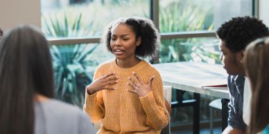 Young woman speaking in group discussion.