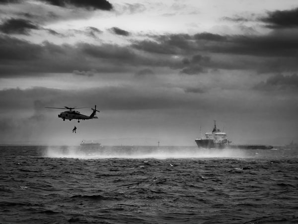 Military rescue operation with a helicopter and ship
