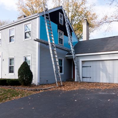 House exterior with ladders for siding repair or installation.