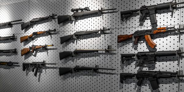 Various rifles displayed on a pegboard wall.