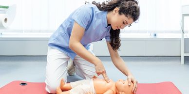 Person practicing CPR on infant doll.