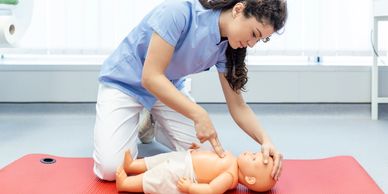 Person practicing CPR on infant doll.