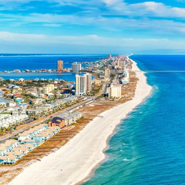 A coastal city with high-rise buildings and a sandy beach.