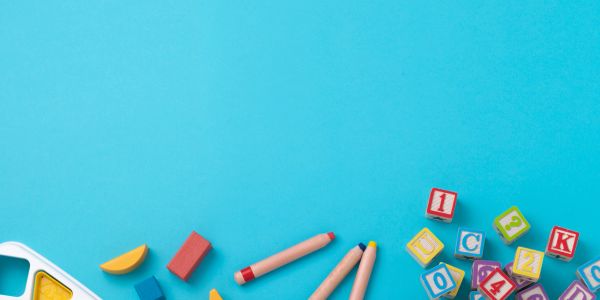 Colorful children's toys and building blocks scattered on a blue surface.