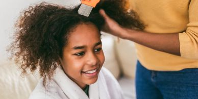 A girl smiling while having her hair brushed.