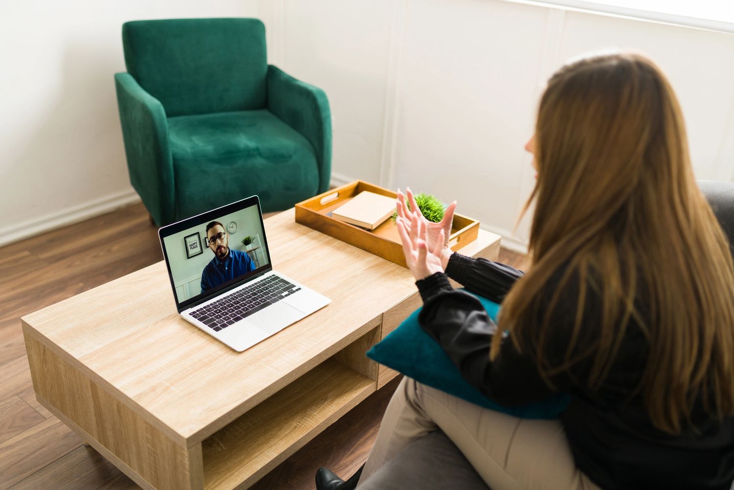 Woman having a video call on a laptop in a cozy room.
