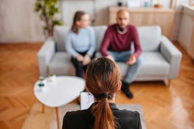 Couple talking with a therapist in a cozy room for relationship counseling