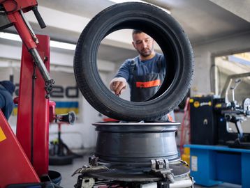 Mechanic inspecting a tire in an auto repair shop.