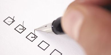 Marking checkboxes on a checklist with a pen.