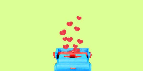 Blue typewriter with red keys and floating red hearts on a light green background.