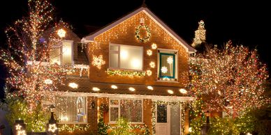 A house beautifully adorned with colorful Christmas lights and decorations at night.