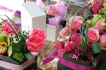 Bouquets of pink flowers with green accents and ribbons.