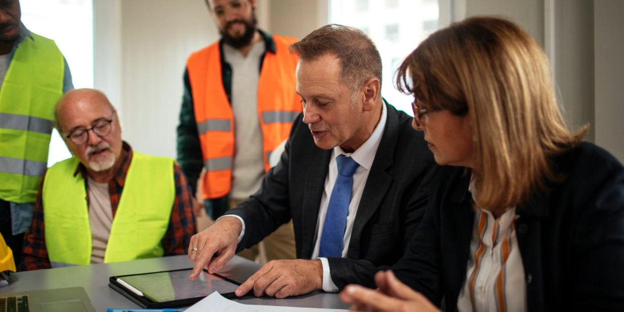 Businessman discussing project with workers.