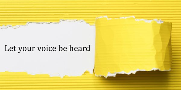 Torn yellow paper reveals the message: Let your voice be heard.