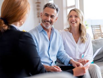 A happy couple consulting with a professional indoors.