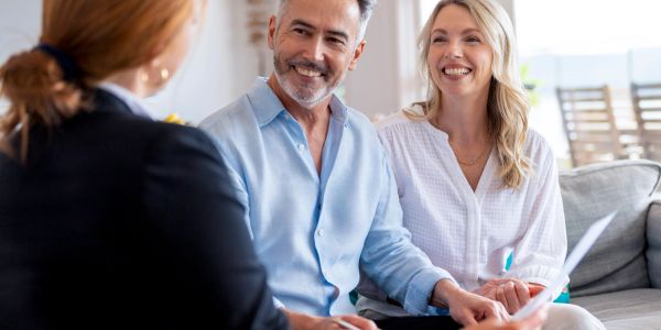 Happy couple talking to a professional in a consultation.