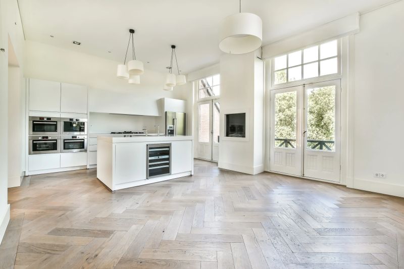 beautiful kitchen in new luxury home with island, pendant lights, hardwood floors, and stainless steel appliances