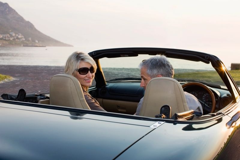 Couple in convertible admiring coastline