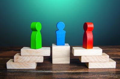 Colored wooden figures balanced on wooden blocks.