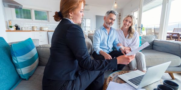 Couple consulting a female advisor at home.