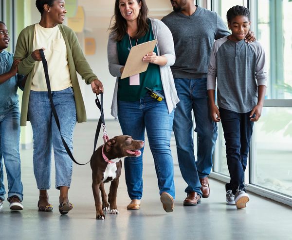 Group walking together with a dog and clipboard.